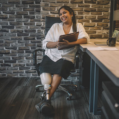 Image of woman with prosthetic leg sitting and smiling